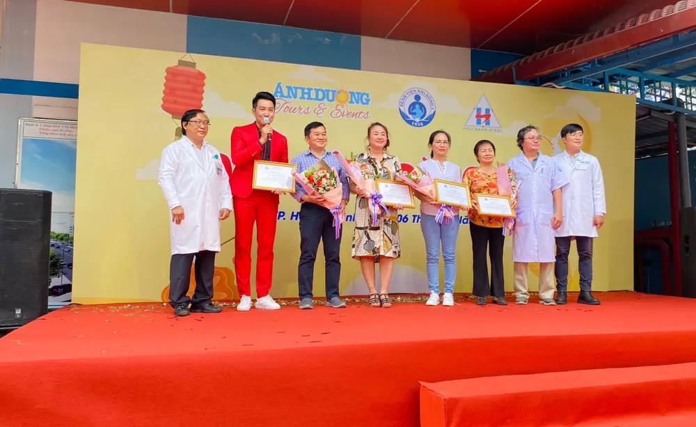 Ca sĩ Phi Hùng cùng các nhà hảo tâm nhận thư cảm ơn từ Bệnh viện Nhi đồng 1. Ảnh: MINH THẢO