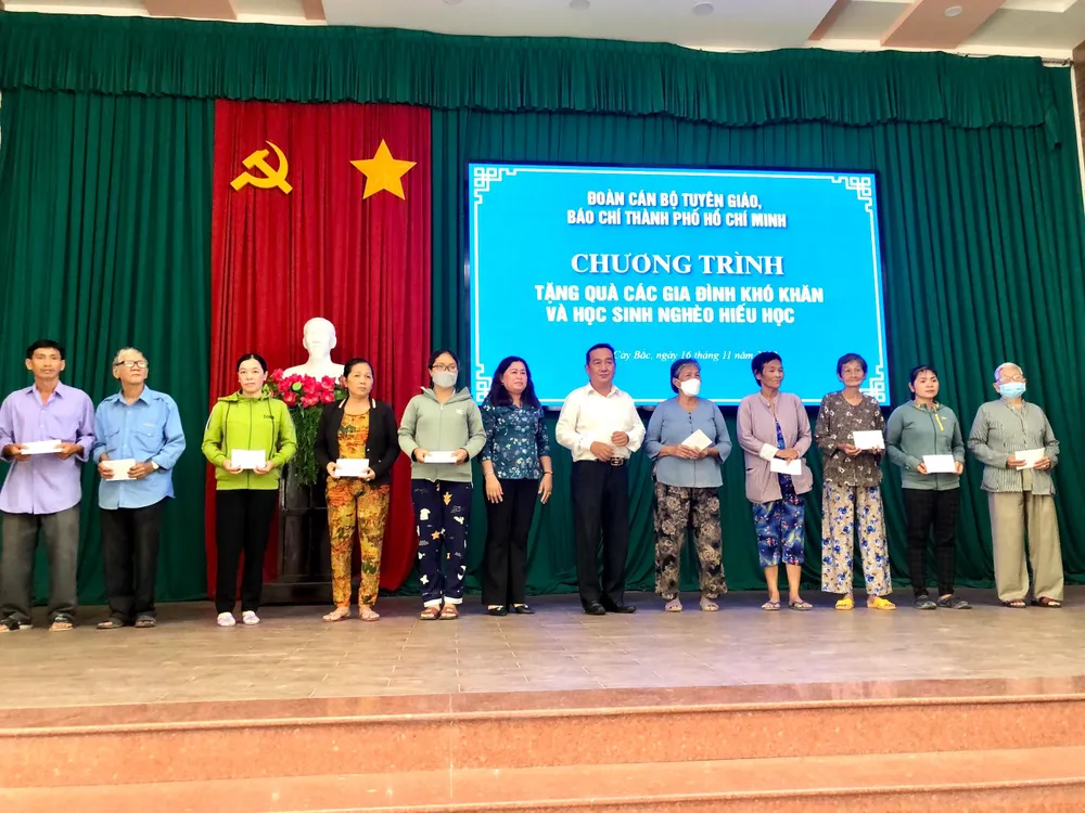 Đoàn cán bộ, báo chí, xuất bản TP.HCM tặng quà cho các gia đình khó khăn ở huyện Mỏ Cày Bắc, Bến Tre. Ảnh: QUANG HUY