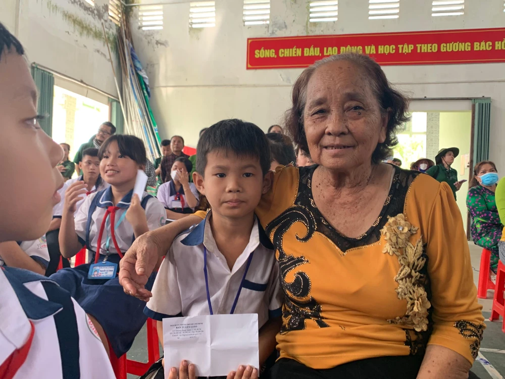 Bà Trần Thị Tuyết cùng cháu vui mừng khi được nhận quà. Ảnh: H.LAN