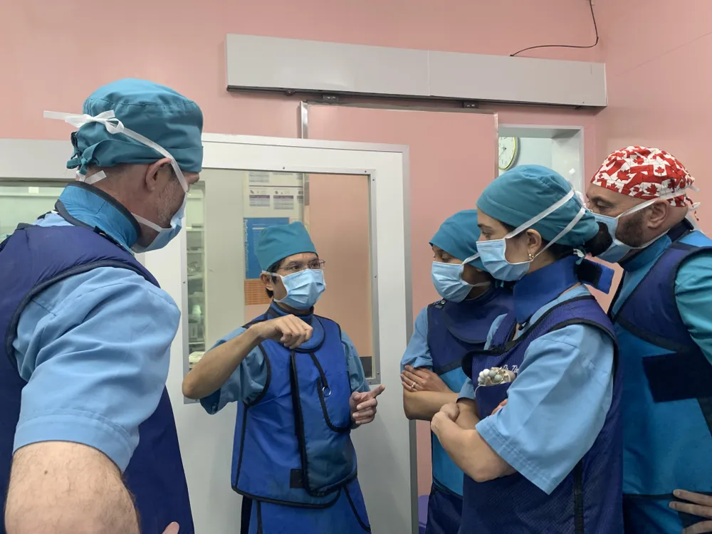 Bộ đồ bảo hộ nặng hơn 5 kg mỗi lần vào phòng can thiệp tim mạch BS Đỗ Nguyên Tín (giữa) phải mặc. Ảnh: HL Bộ đồ bảo hộ nặng hơn 5 kg mỗi lần vào phòng can thiệp tim mạch BS Đỗ Nguyên Tín (giữa) phải mặc. Ảnh: HL