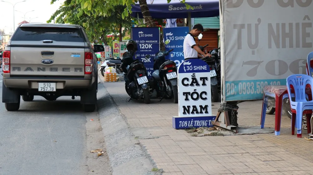 Biển hiệu quảng cáo của một hiệu tóc trên đường Lê Trọng Tấn (quận Tân Phú). Ảnh: HT cot-moc-giao-thong-bien-tuong-voi-dong-chu-la.jpg
