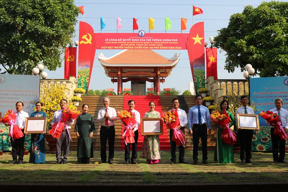 Ông Ngô Minh Châu, Phó Chủ tịch UBND TP.HCM và ông Trần Hoàng Danh, Bí thư Quận ủy trao Quyết định của Thủ tướng Chính phủ về công nhận phường An toàn khu cho đại diện 3 phường quận 12.~2.JPG