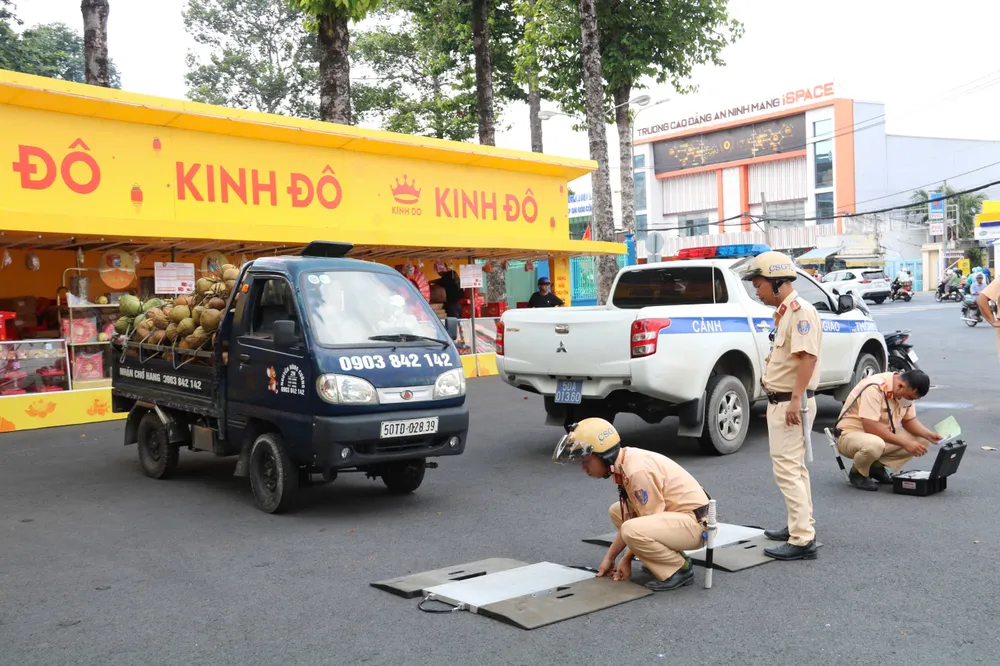 Lực lượng CSGT TP Thủ Đức sử dụng cân điện tử đo trọng lượng. Ảnh: NN TP Thủ Đức (12).jpg