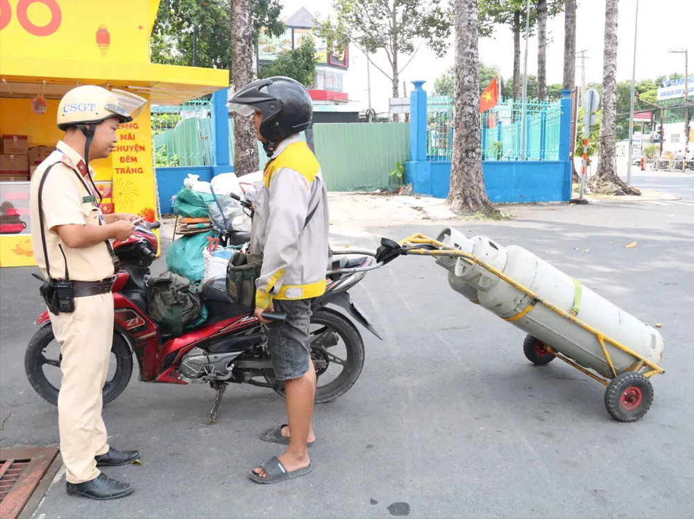 Lực lượng CSGT xử lý một trường hợp xe máy tự chế chở hàng cồng kềnh. Ảnh: NT xe ô tô tải (6).jpg