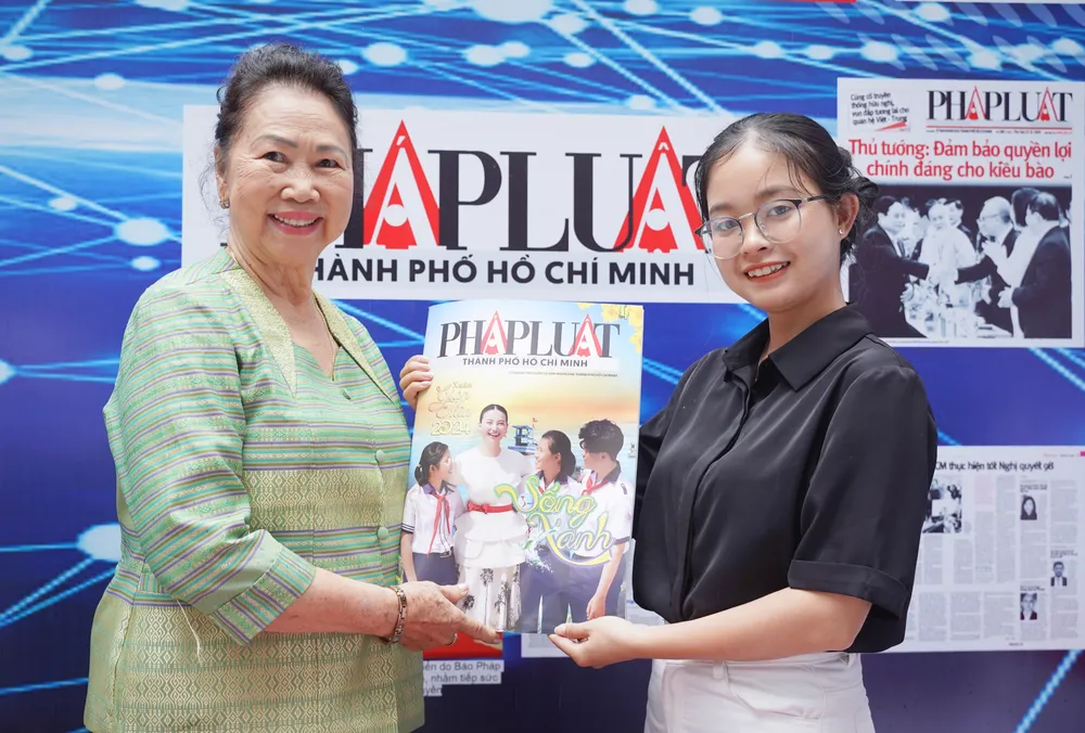 Bà Nguyễn Thị Thụy (trái) - Phó Trưởng ban Liên lạc kiều bào Lào - Thái Lan - TP.HCM tham quan gian hàng trưng bày ấn phẩm của Báo Pháp Luật TP.HCM. Ảnh: THUẬN VĂN kiều bào (1).jpg