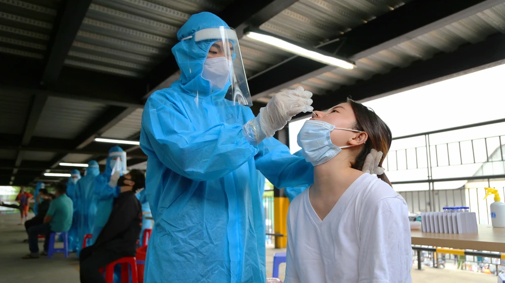 Nhân viên y tế lấy mẫu xét nghiệm COVID-19. Ảnh: HOÀNG GIANG