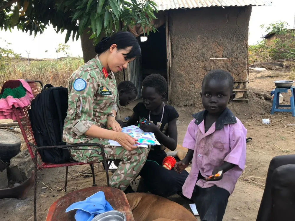 Trung tá Đỗ Thị Hằng Nga tặng một số hộp màu, giấy để các em vẽ những ước mơ về tương lai của mình. Ảnh: GGHBVN