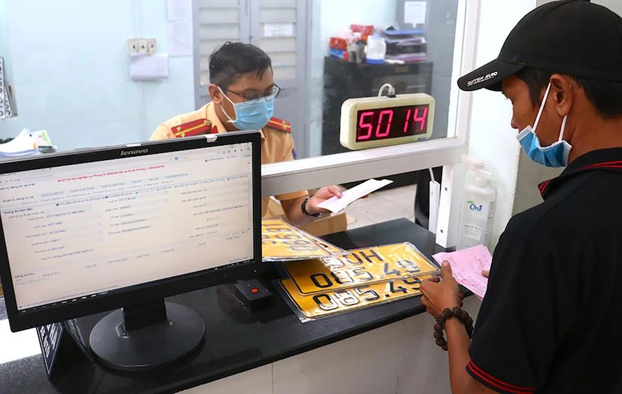 CSGT TP.HCM thực hiện đổi biển số nền vàng. Ảnh: LÊ THOA