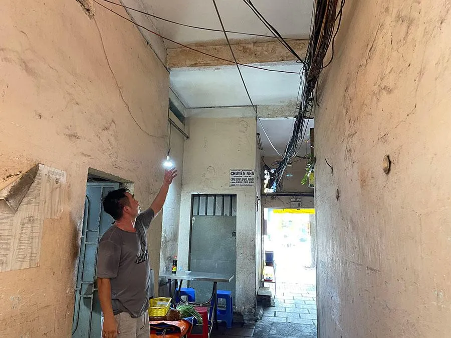 Người dân tại chung cư 137 Lý Thường Kiệt chỉ lên tấm đà ngay cổng ra vào chung cư thường xuyên bị nước nhỏ xuống lối đi suốt nhiều năm nay. Ảnh: VIỆT HOA