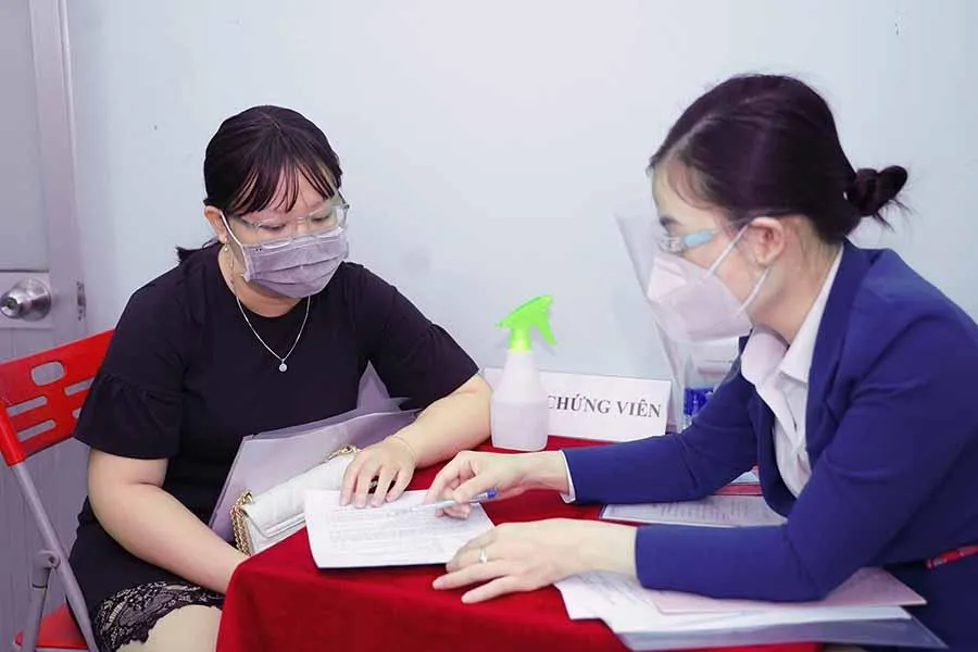 Công chứng viên hướng dẫn người dân thủ tục làm hợp đồng. Ảnh: Q.HUY Công chứng viên hướng dẫn người dân thủ tục làm hợp đồng. Ảnh: Q.HUY