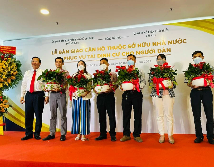 Chủ tịch UBND TP Phan Văn Mãi (bìa trái) chúc mừng các gia đình nhận bàn giao căn hộ mới. Ảnh: V.HOA