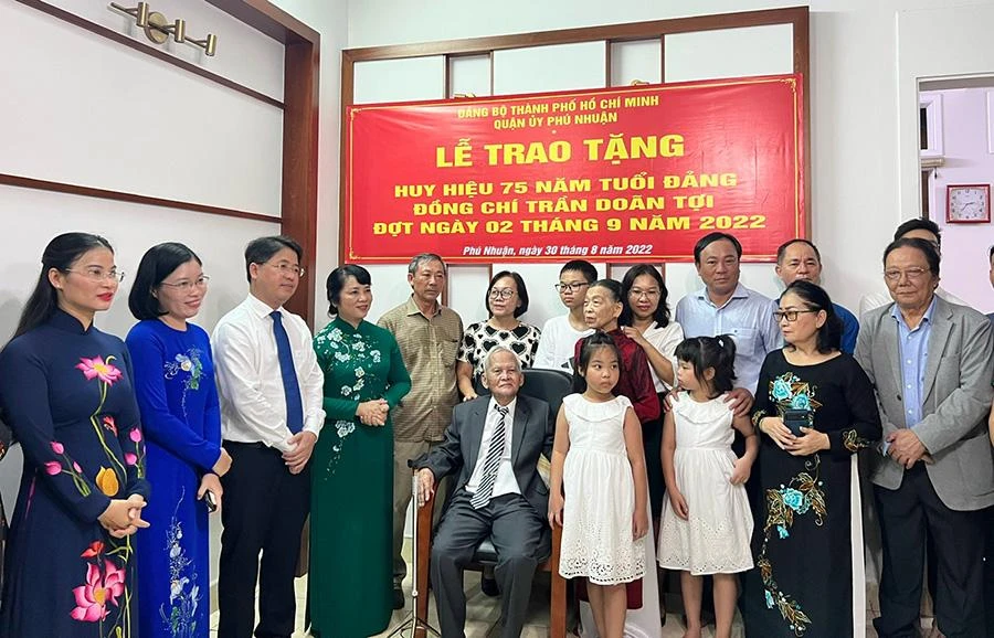 Đoàn công tácThành ủy, Quận ủy và Đảng ủy phường trao tặng huy hiệu Đảng cho ông Tợi. Ảnh: NGUYỄN YÊN