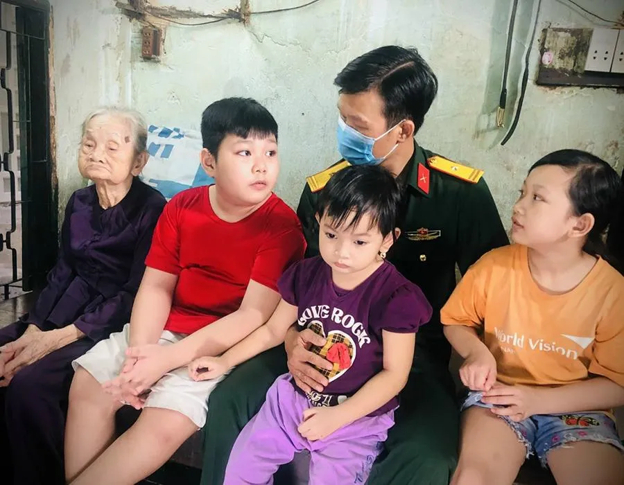 Thiếu tá Nguyễn Trung Kiên cùng ba người con mà anh nhận đỡ đầu trong một lần bàn giao tro cốt nạn nhân tử vong do COVID-19 về với gia đình. Ảnh: NVCC Thiếu tá Nguyễn Trung Kiên cùng ba người con mà anh nhận đỡ đầu trong một lần bàn giao tro cốt nạn nhân tử vong do COVID-19 về với gia đình. Ảnh: NVCC