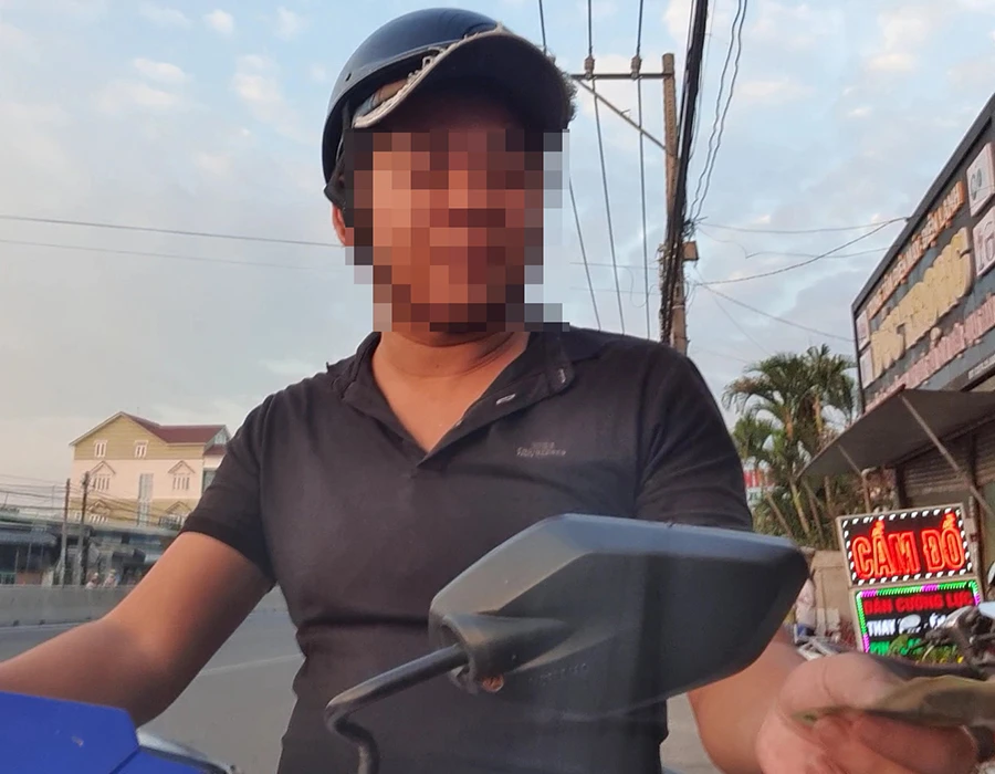 Chiều 14-12-2022, người tên Vũ chạy xe máy đi giao các loại giấy tờ giả và nhận tiền. Ảnh: N.YÊN
