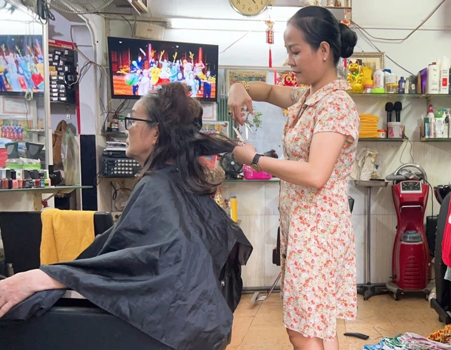 Thảo “bao đồng” đang cắt tóc miễn phí cho người nghèo. Ảnh: NGUYỄN ĐƯỚC