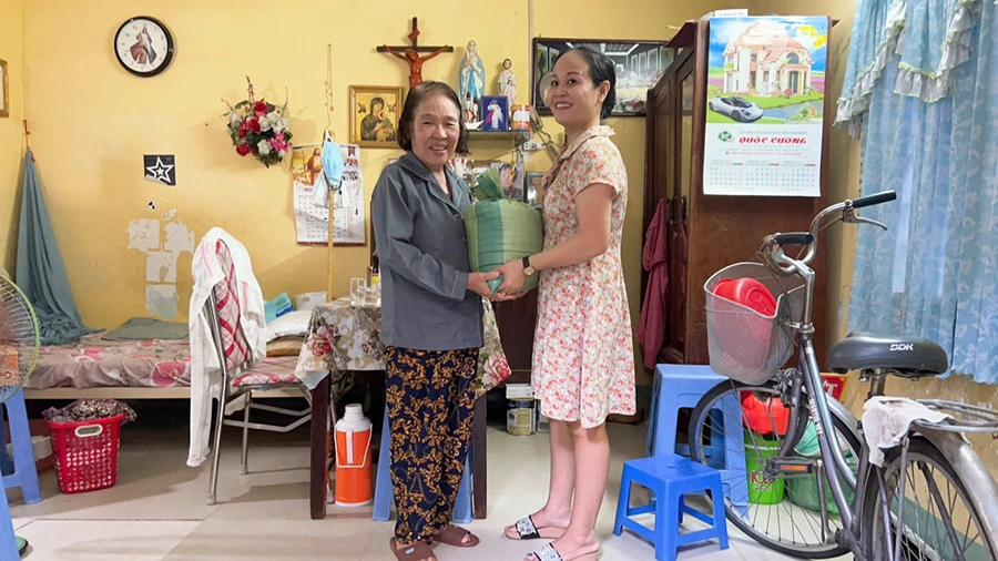 Thảo “bao đồng” trao gạo ngon cho bà Nguyễn Thị Nguyệt. Ảnh: NGUYỄN ĐƯỚC