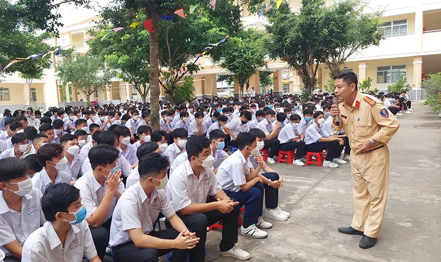 Cán bộ Đội CSGT trật tự Công an TP Tân An, Long An tuyên truyền cho học sinh các quy định đối với người điều khiển xe đạp điện, xe điện. Ảnh: H.DU