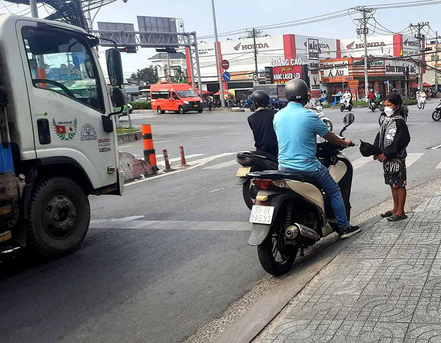 Bé gái cầm nón xin tiền ở ngã tư Trung Chánh, huyệnHócMôn, TP.HCM. Ảnh: TRẦN NGỌC Bé gái cầm nón xin tiền ở ngã tư Trung Chánh, huyệnHócMôn, TP.HCM. Ảnh: TRẦN NGỌC