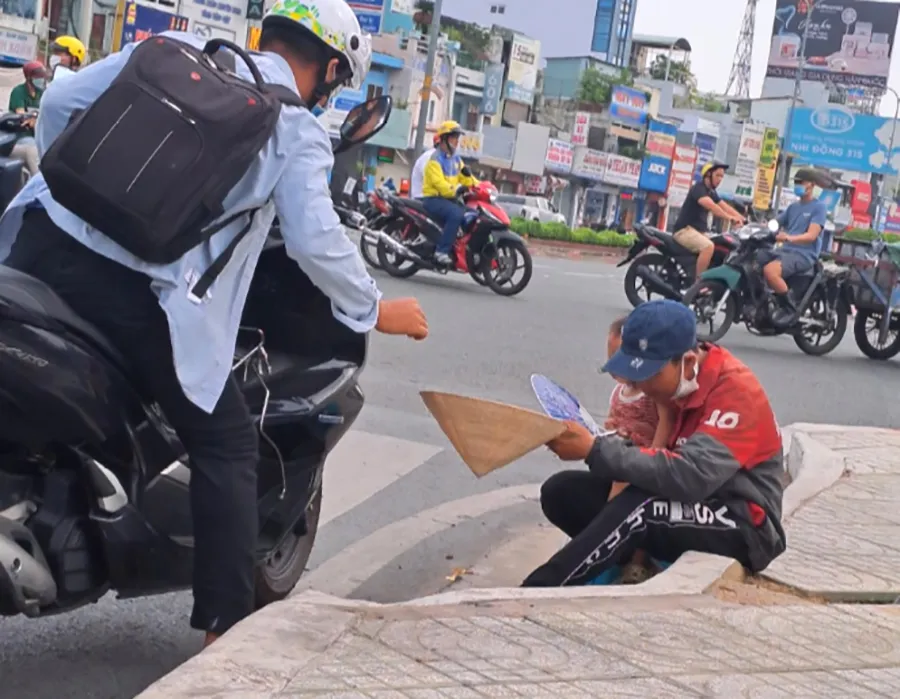 Người đàn ông bế con xin tiền người đi đường ở ngã tư Bảy Hiền, quận Tân Bình, TP.HCM. Ảnh: TRẦN NGỌC Người đàn ông bế con xin tiền người đi đường ở ngã tư Bảy Hiền, quận Tân Bình, TP.HCM. Ảnh: TRẦN NGỌC