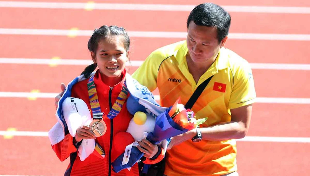 HLV Trần Văn Sỹ dìu VĐV Phạm Thị Hồng Lệ lên bục nhận HCĐ ở SEA Games 2019. Ảnh: Nhân vật cung cấp