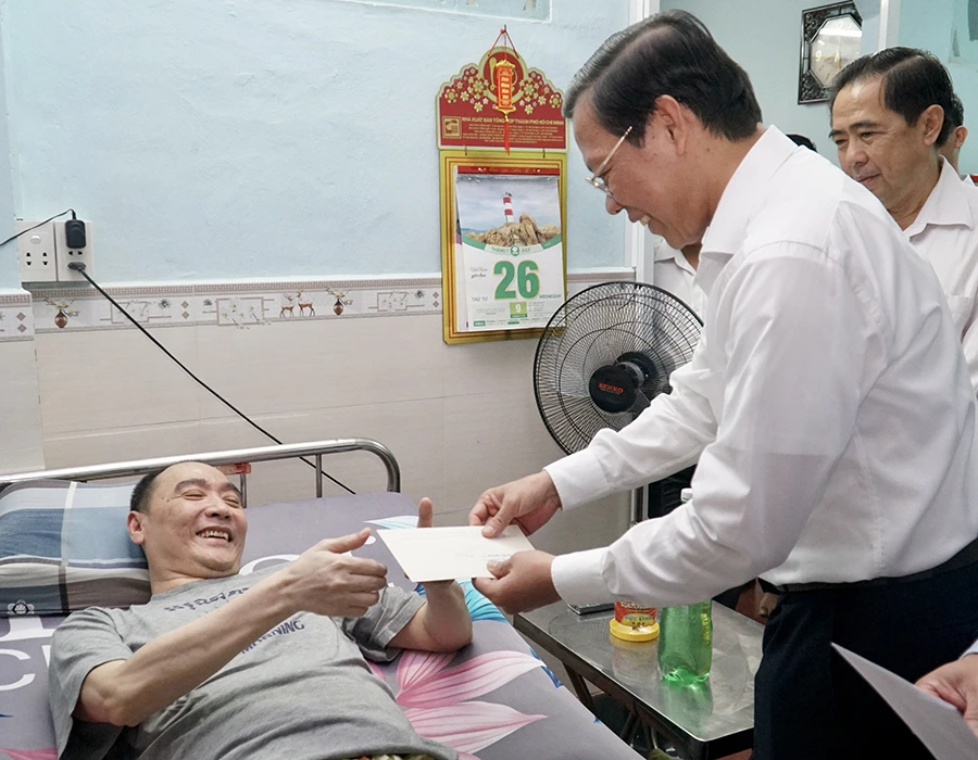 Chủ tịch UBND TP.HCM Phan Văn Mãi thăm ông Huỳnh Lập Hiến (57 tuổi), thương binh đặc biệt nặng hạng 1/4 với tỉ lệ thương tật 92%. Ảnh: BẢO PHƯƠNG