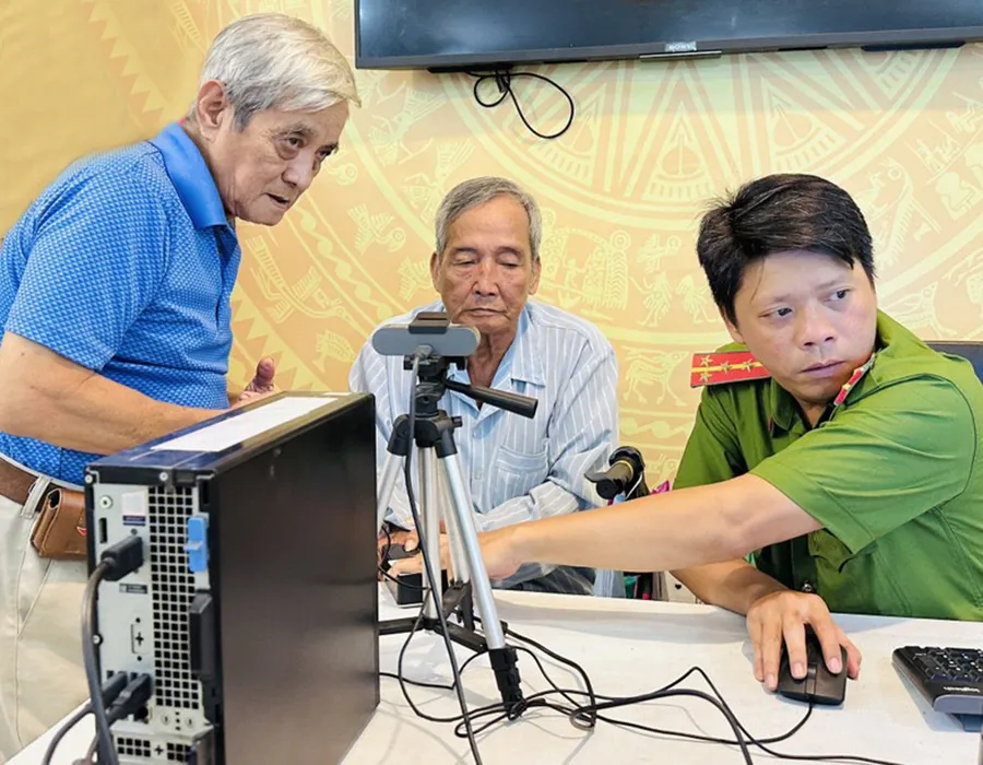 Do lớn tuổi, không có điện thoại thông minh nên ông NVH (giữa) gặp khó khăn khi làm tài khoản định danh điện tử. Ảnh: HUỲNH THƠ