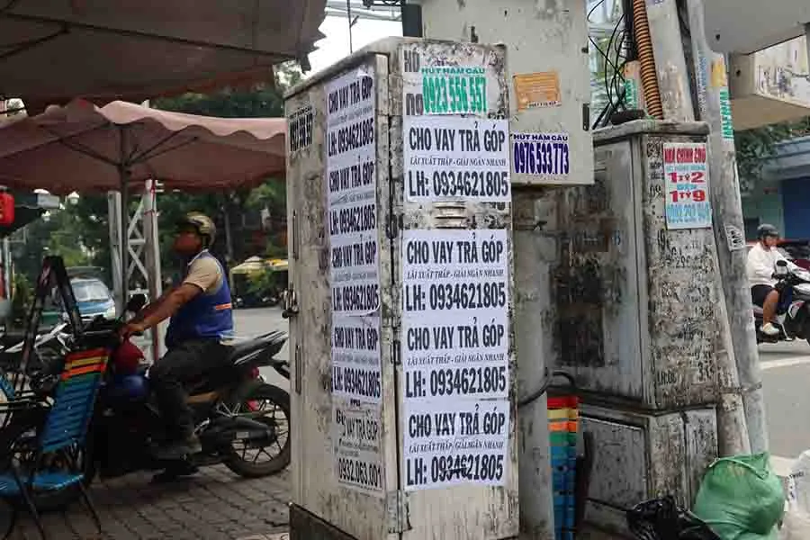 Những số điện thoại trong các quảng cáo dán trên trụ điện có thể bị thu hồi. Ảnh: TRẦN MINH Quang-cao-tru-dien_12-10.jpg