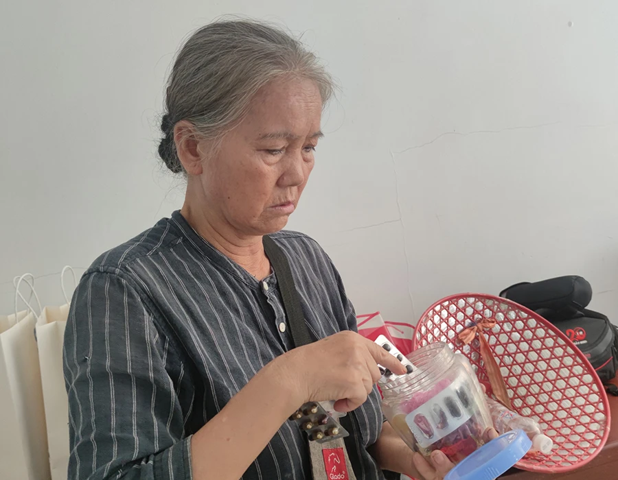 Bà Nguyễn Thị Bé nhiều tháng nay phải tự mua thuốc ở cửa hàng thuốc vì không có thẻ BHYT để khám chữa bệnh. Ảnh: NGUYỄN HIỀN Tang-the-BHYT_9-11.jpg