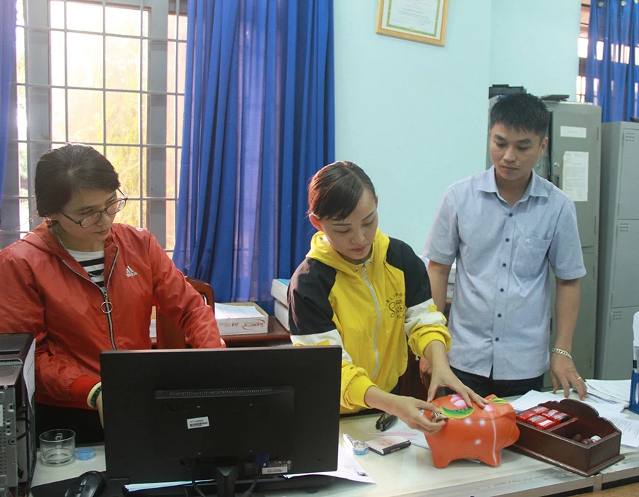 Mỗi ngày đến cơ quan làm việc, cán bộ trên địa bàn huyện Cư M’gar đều thực hiện bỏ tiền vào heo đất tiết kiệm. Ảnh: HOÀNG QUÂN P12_can-bo-nuoi-heo-dat_h2.jpg