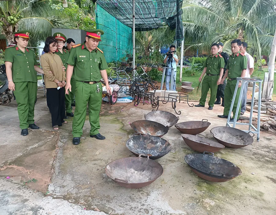 Bắt giam bà Nguyễn Thị Hoài Diễm, bên cạnh là các chảo dùng để đốt lửa hành hình các hình nộm. Ảnh:PHÚ NHUẬN p5_phu1_chuyende_thientrieunamquoc_ttam.jpg