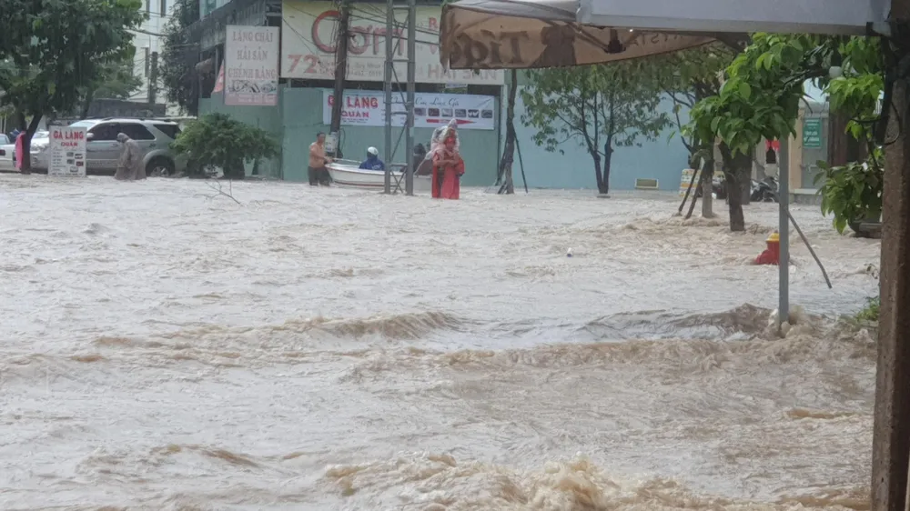 Nước lớn nhanh khiến người dân không kịp trở tay. Ảnh: QN