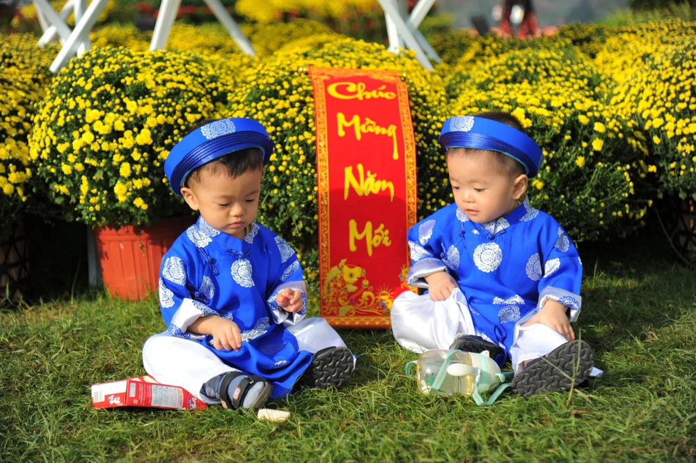 Nhiều em bé mặc đồ đẹp được bố mẹ đưa đến quảng trường hoa để check-in sớm. Ảnh QN