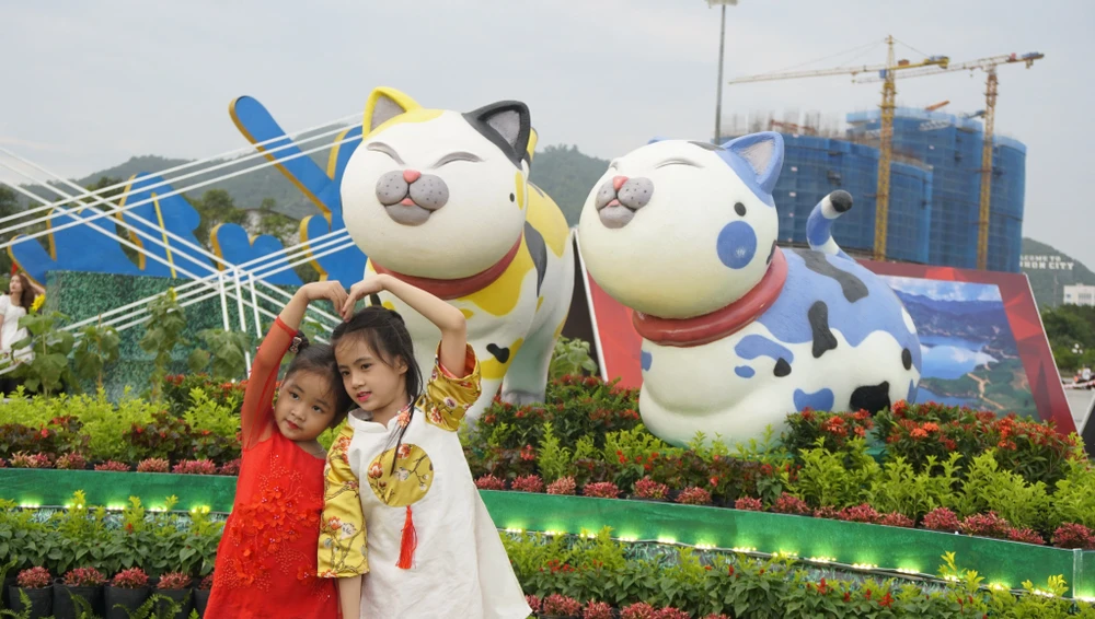 Hai bé gái chụp ảnh với linh vật ngộ nghĩnh của năm. Ảnh QN