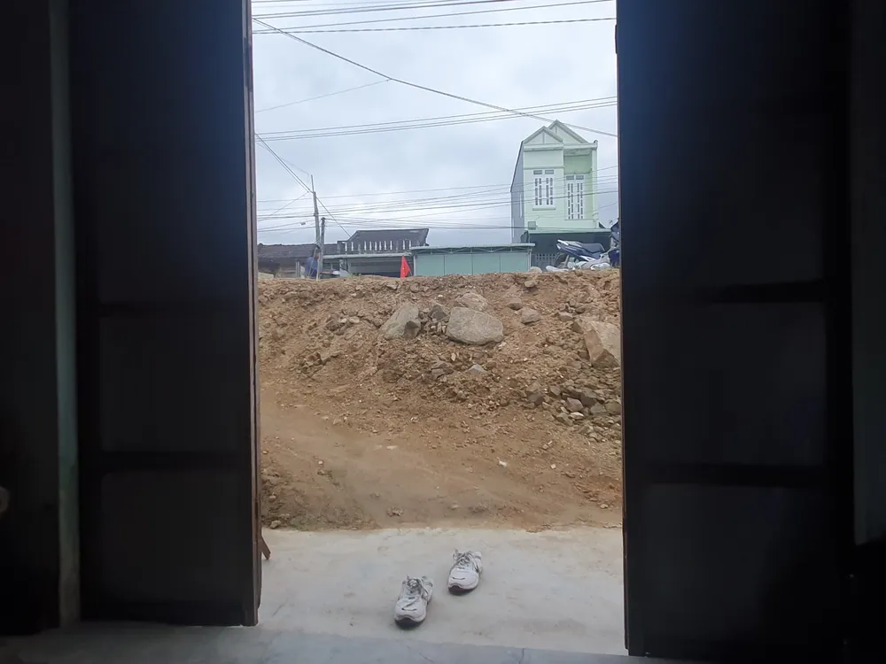 Mặt đường chắn ngay cửa nhà người dân khiến việc đi lại khó khăn. Ảnh QN Mặt đường chắn ngay cửa nhà người dân khiến việc đi lại khó khăn. Ảnh QN