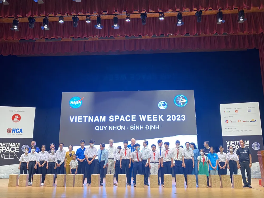 Các phi hành gia tặng quà cho 20 học sinh vượt khó học tốt của Bình Định. Ảnh QN