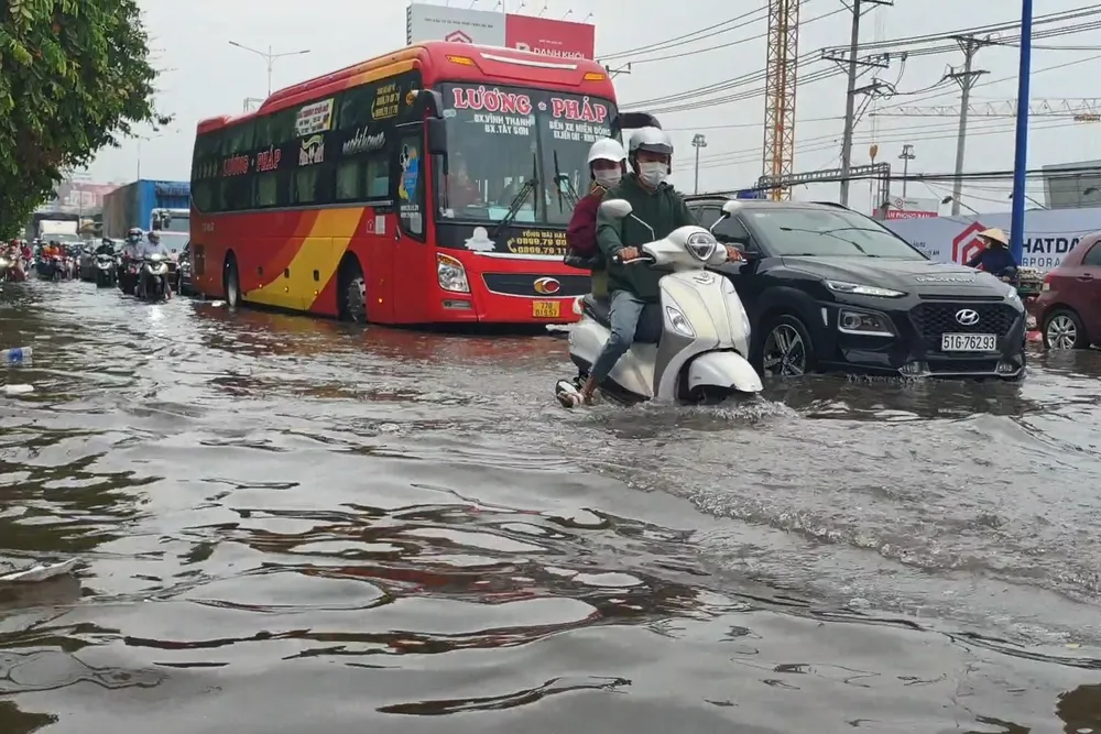 Các phương tiện di chuyển trong biển nước trên quốc lộ 13. Ảnh: LA Các phương tiện di chuyển trong biển nước trên quốc lộ 13. Ảnh: LA