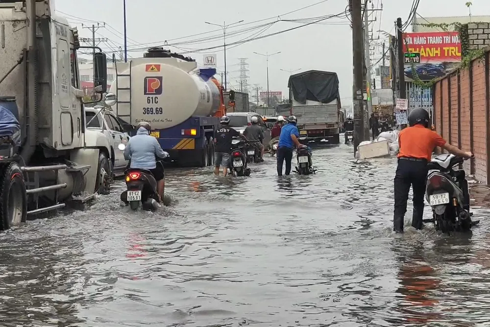 Một số người dân phải dắt bộ lội nước do xe bị chết máy. Ảnh: LA Một số người dân phải dắt bộ lội nước do xe bị chết máy. Ảnh: LA