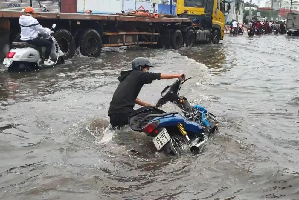Một người dân bị ngã khi đi qua đoạn đường bị ngập. Ảnh: LA Một người dân bị ngã khi đi qua đoạn đường bị ngập. Ảnh: LA