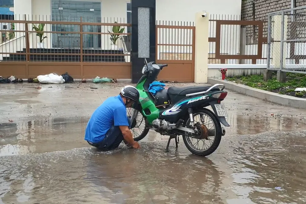 Xe máy bị chết máy do ngập nước, người dân loay hoay tìm cách sửa chữa. Ảnh: LA Xe máy bị chết máy do ngập nước, người dân loay hoay tìm cách sửa chữa. Ảnh: LA