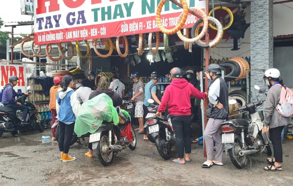 Các tiệm sửa xe hai bên đường đông ngẹt người sửa xe do bị chết máy. Ảnh: LA Các tiệm sửa xe hai bên đường đông ngẹt người sửa xe do bị chết máy. Ảnh: LA