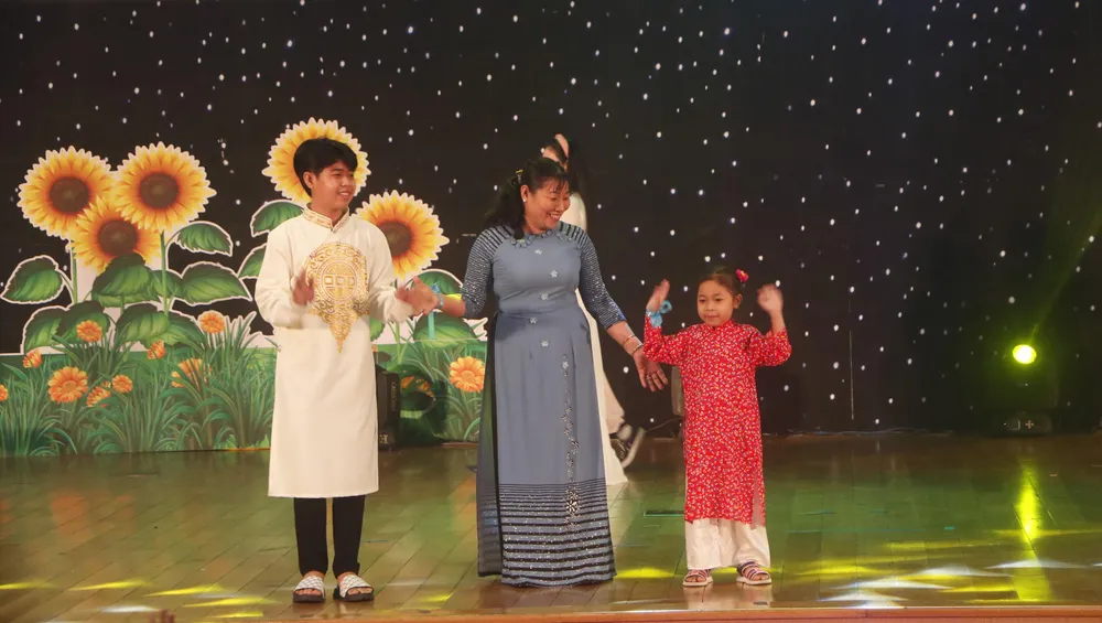Mẹ đỡ đầu cùng các con biểu diễn áo dài tại chương trình &quot;Mẹ đỡ đầu- yêu thương và sẻ chia&quot;. Ảnh: LÊ ÁNH