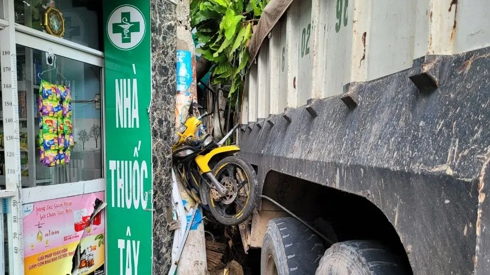 Một chiếc xe máy bị húc văng cao kẹt giữa xe ben và cột điện. Ảnh: LA Một chiếc xe máy bị húc văng cao kẹt giữa xe ben và cột điện. Ảnh: LA