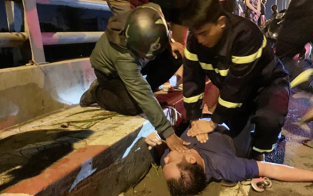 Lực lượng cứu hộ sơ cứu ngay sau khi vớt được nạn nhân lên bờ. Ảnh: CACC