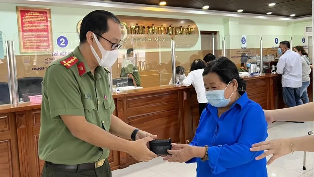 Đại úy Khánh trao trả chiếc bóp có tiền và vàng cho người dân để quên. Ảnh: LA