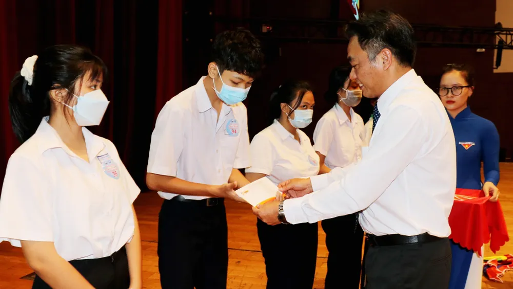 Ông Nguyễn Lộc Hà, Phó Chủ tịch UBND tỉnh Bình Dương trao học bổng có các em học sinh. Ảnh: PC