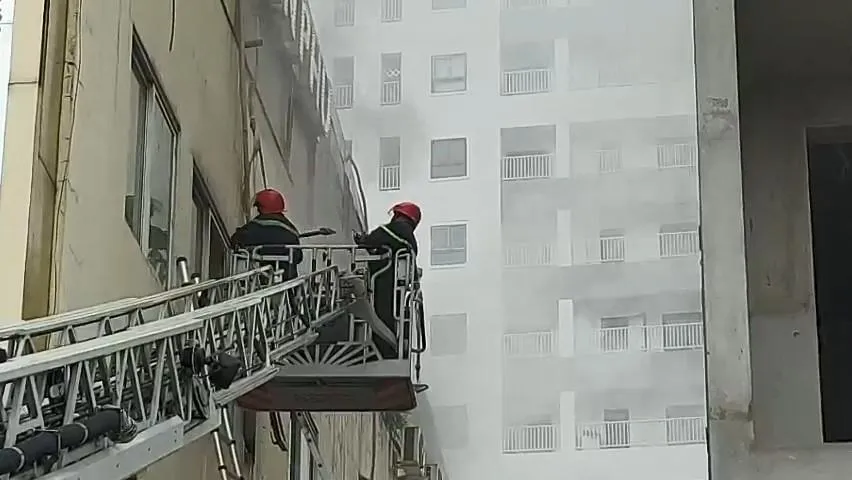 Lực lượng cứu hộ dùng búa đập kính từ tầng ba để tìm cách vào bên trong. Ảnh: LÊ ÁNH Lực lượng cứu hộ dùng búa đập kính từ tầng ba để tìm cách vào bên trong. Ảnh: LÊ ÁNH