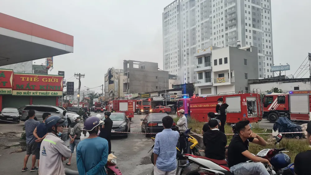 Thân nhân nhiều người bị mắc kẹt trong vụ cháy đang đứng đợi tin từ phía cơ quan chức năng. Ảnh: LÊ ÁNH