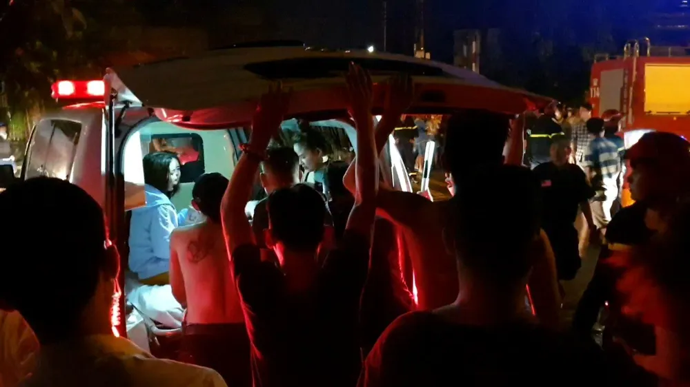 Nhân viên quán karoke được cứu ra ngoài đưa đi cấp cứu. Ảnh: LÊ ÁNH