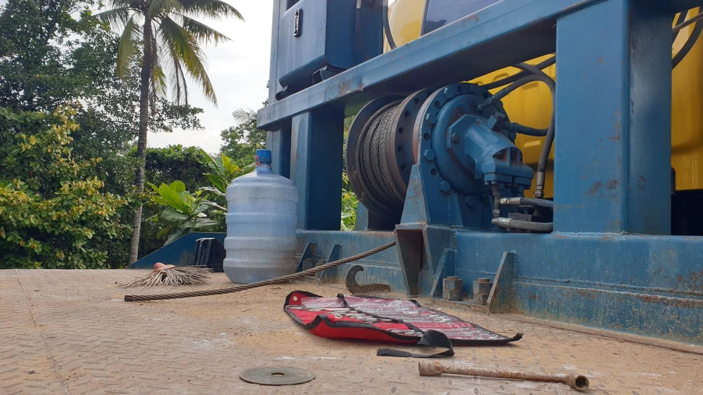 Dây cáp bị đứt khi đang kéo xe lu lên xe đầu kéo. Ảnh: LÊ ÁNH