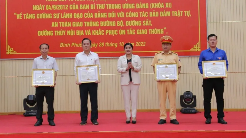 Bà Trần Tuệ Hiền, Chủ tịch UBND tỉnh Bình Phước tặng bảng khen cho các tập thể và cá nhân có thành tích xuất sắc trong việc thực hiện Chỉ thị số 18. Ảnh: DH